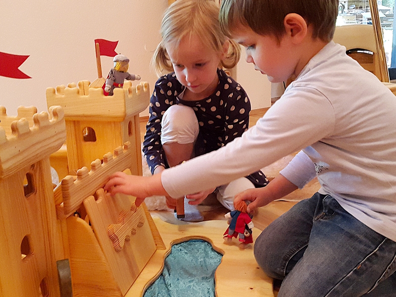 Begeisterte Kinder beim Spielen mit Holzburg